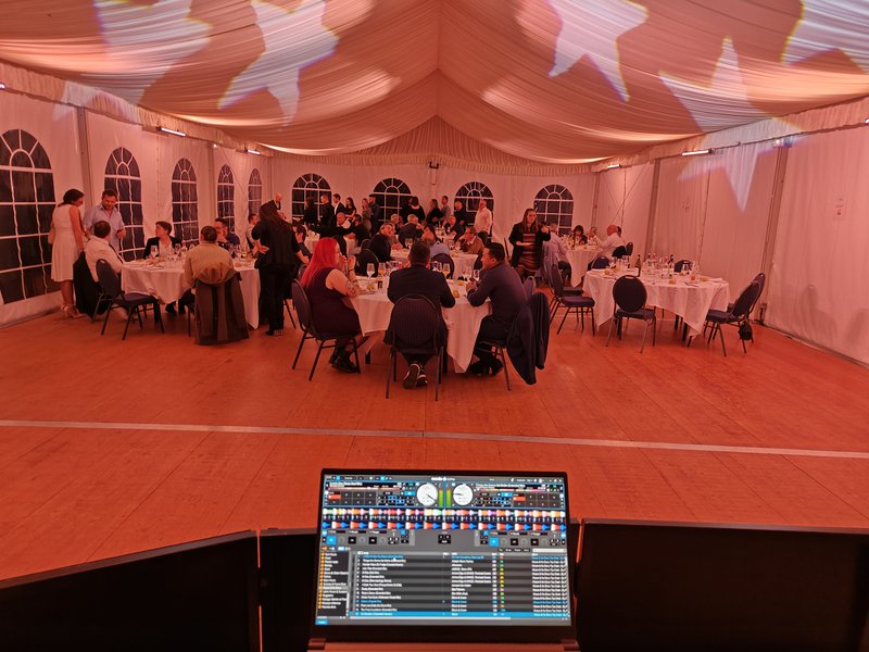 Dîner d'entreprise sous chapiteau avec régie DJ au premier plan