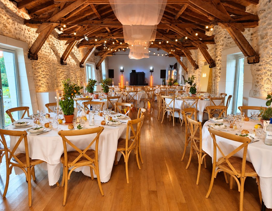 Grande salle de réception avec charpente en bois et tables dressées