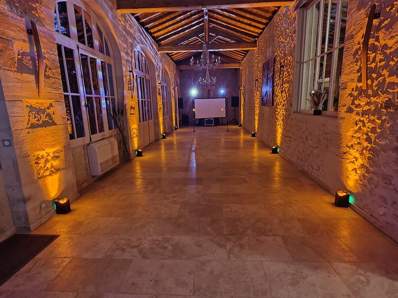 Mise en lumière chaleureuse des murs en pierre de la salle de réception