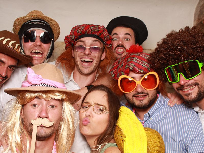 Groupe d'invités posant avec accessoires devant le photobooth