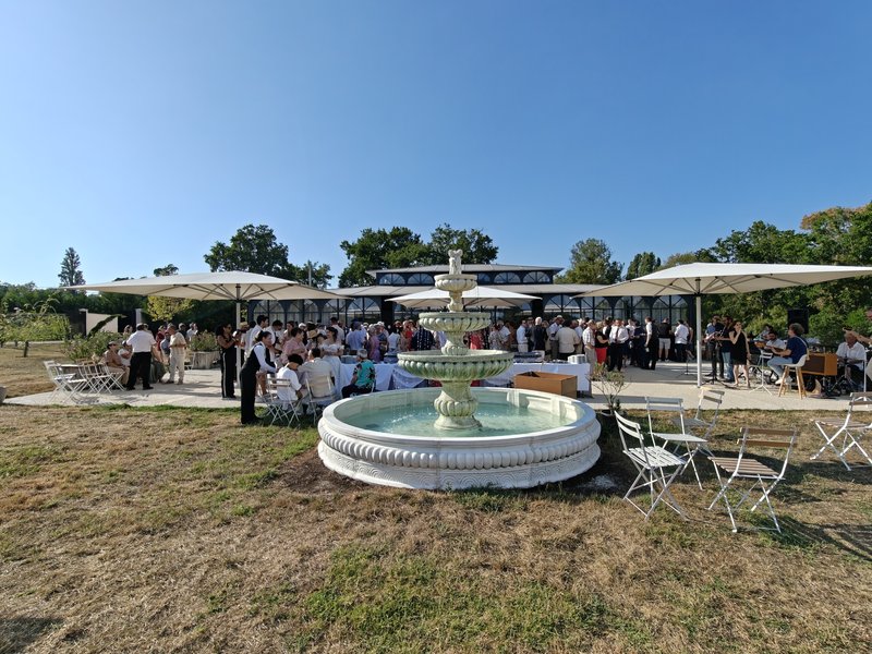 Vin d'honneur en extérieur autour de la fontaine avec les invités et un groupe de musiciens