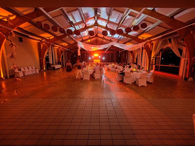Salle de réception habillée de lumières orangées avec piste de danse